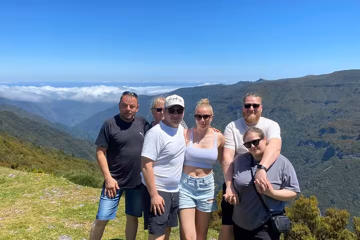 Guests at a mountain viewpoint above the clouds on the West Madeira 4x4 tour to Fanal Forest and skywalk