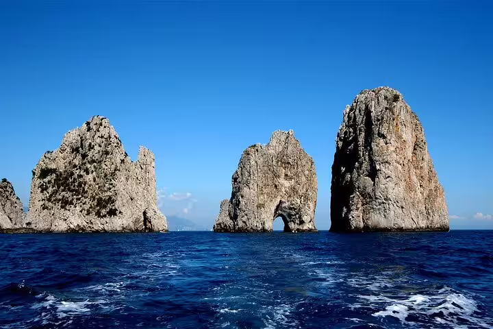 Faraglioni rock formations rising from the blue sea near Capri, seen on a weekly luxury catamaran cruise in Italy