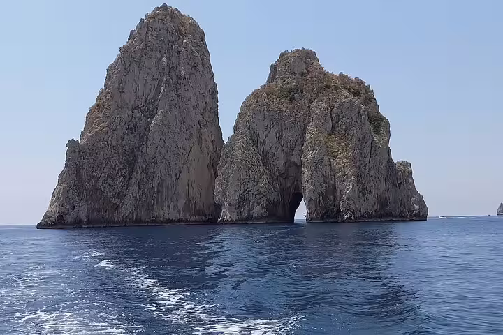 Faraglioni sea stacks and arch seen from a private classic gozzo boat on the Capri 3-hour highlights tour