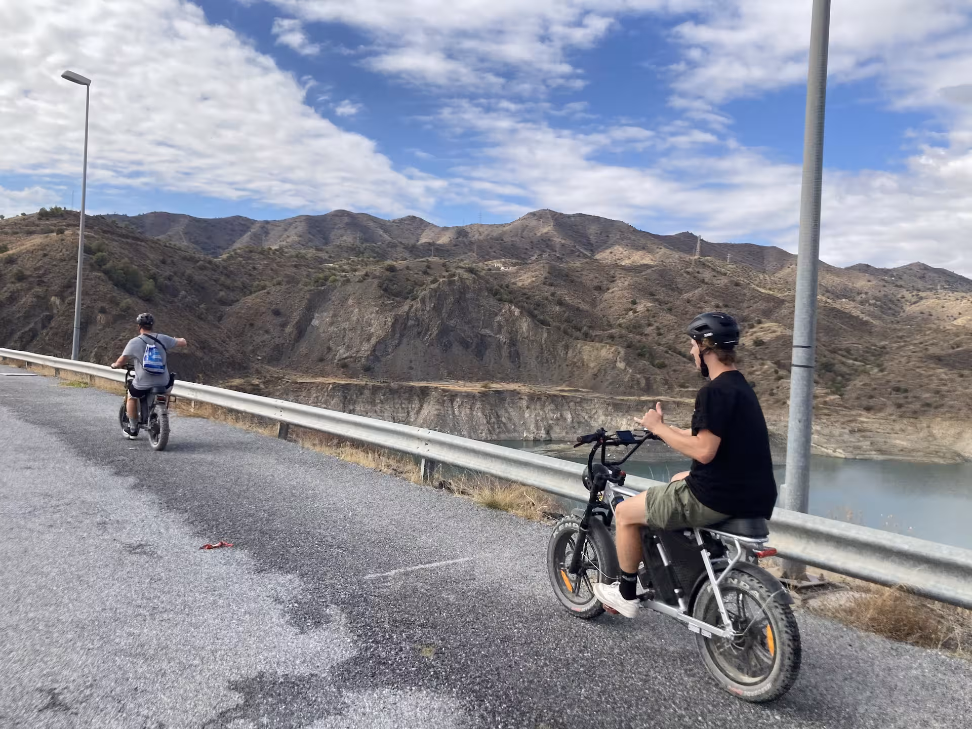Riders on fat tire e-bikes overlooking mountain reservoir on scenic trail during 4-hour e-fat bike rental