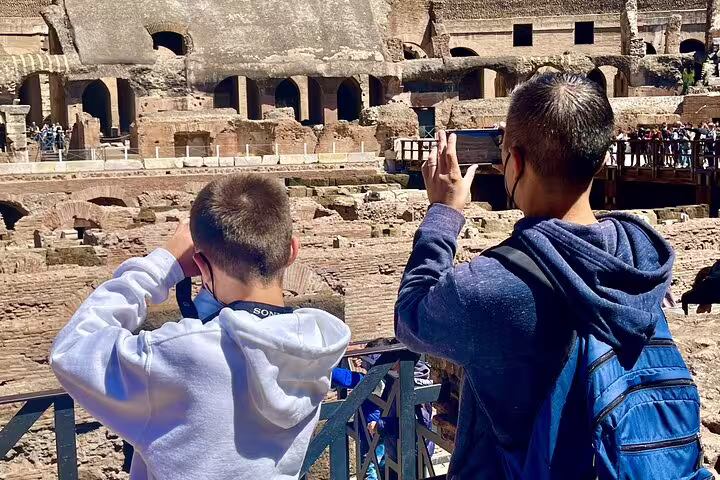 Father and son capturing photos inside the Colosseum during a Rome private VIP tour of the ancient amphitheater