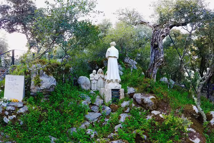 Statues in a serene woodland setting in Fátima highlight the religious significance of the Aljustrel pilgrimage tour.