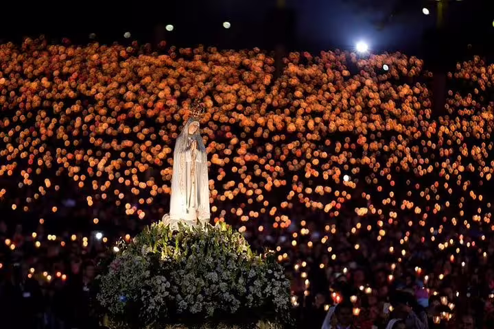 Experience the captivating candlelight procession at Fátima, a highlight of the Porto to Fátima and Coimbra tour.