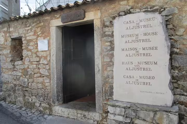 Entrance to the historic Casa-Museu de Aljustrel in Fatima, showcasing multilingual signage on a half-day tour from Lisbon.