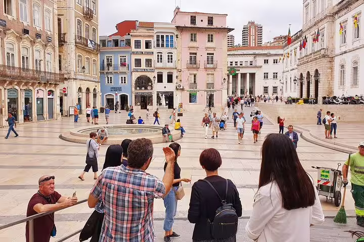 Group tour in Coimbra's historic town square, enjoying the architecture on the Fátima & Coimbra private day tour from Porto.
