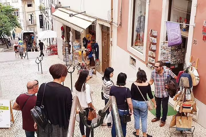 Tourists exploring charming streets and local shops in Coimbra during a private tour from Porto.