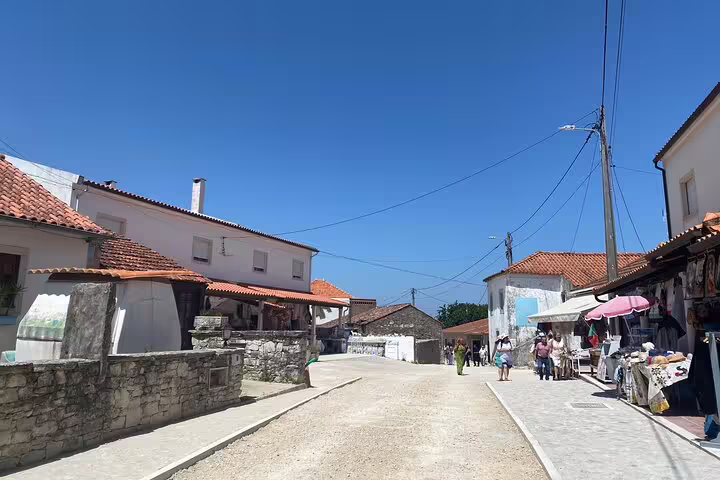 Charming street in Little Shepherds' Village with traditional houses, a key stop on the Fatima tour from Lisbon.