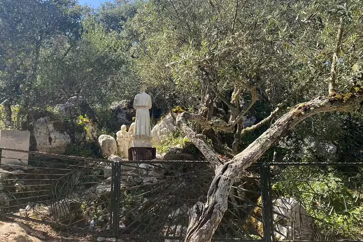 Statues of shepherd children in a natural setting at Little Shepherds' Village, a key attraction on the Fatima tour.