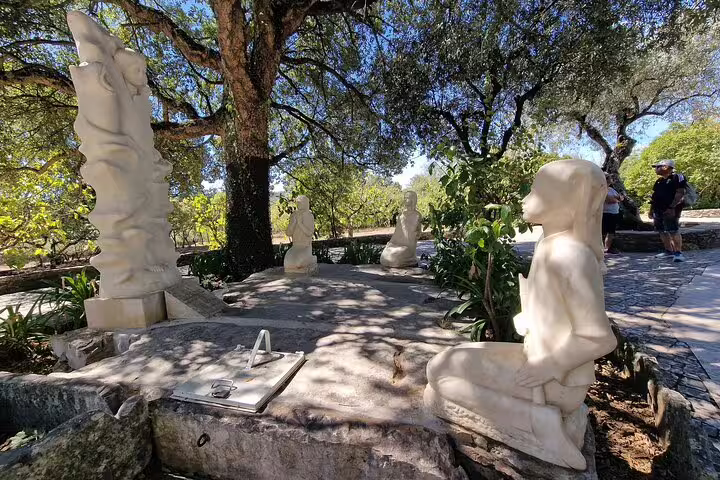 Marble statues under shaded trees in Fatima, Portugal, highlight the serene atmosphere of a full-day private tour from Lisbon.