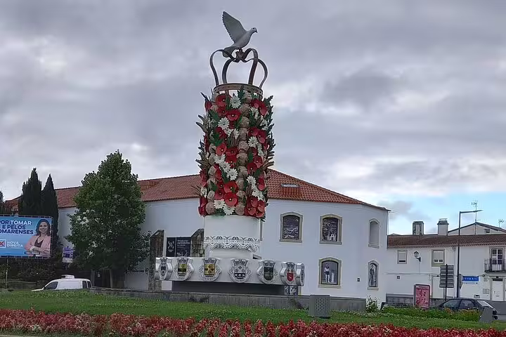 Decorative monument with floral designs and dove sculpture in Fatima, part of the Fatima-Nazare-Obidos tour.
