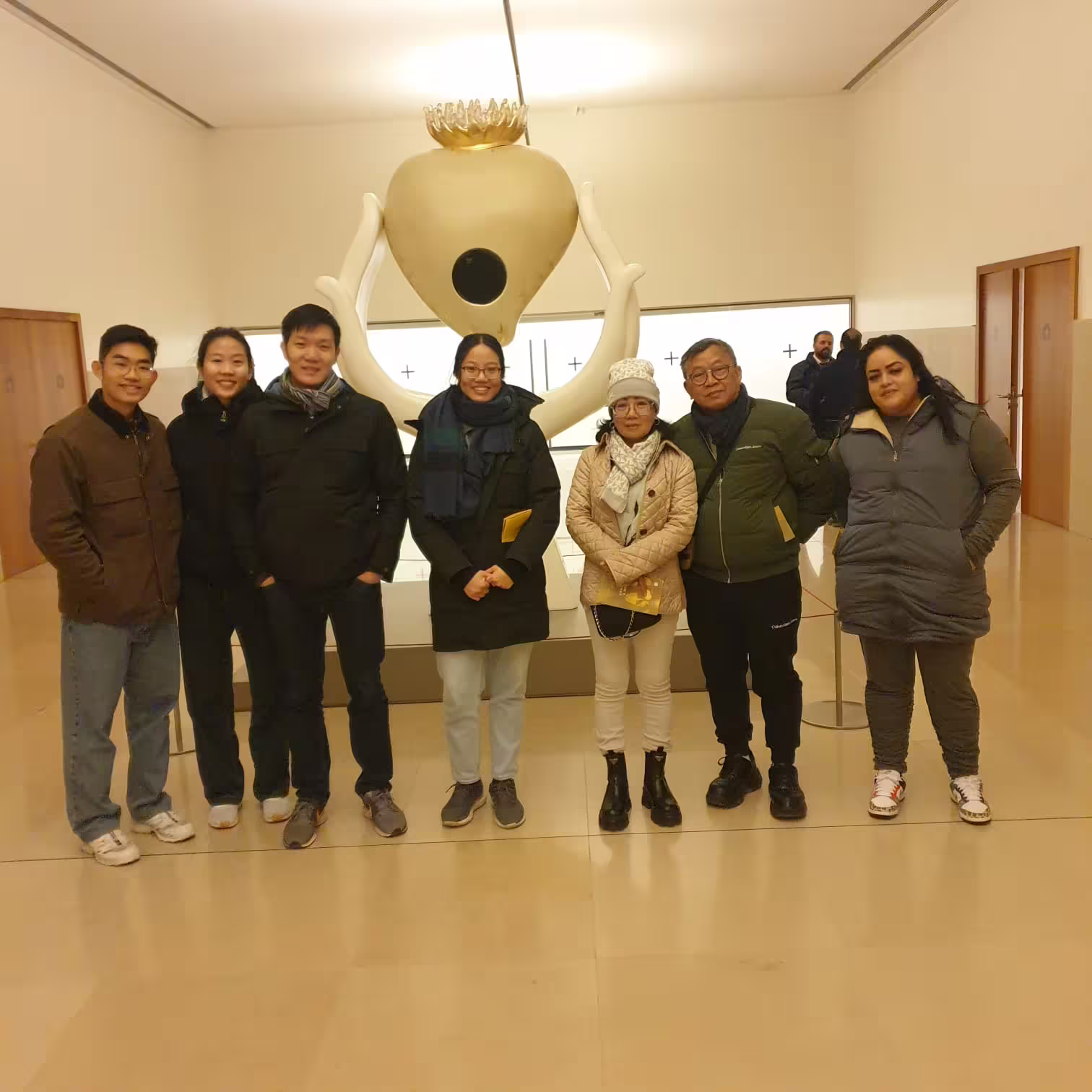 Tour group stands inside the Fátima museum, exploring religious artifacts and learning about the site's rich history.
