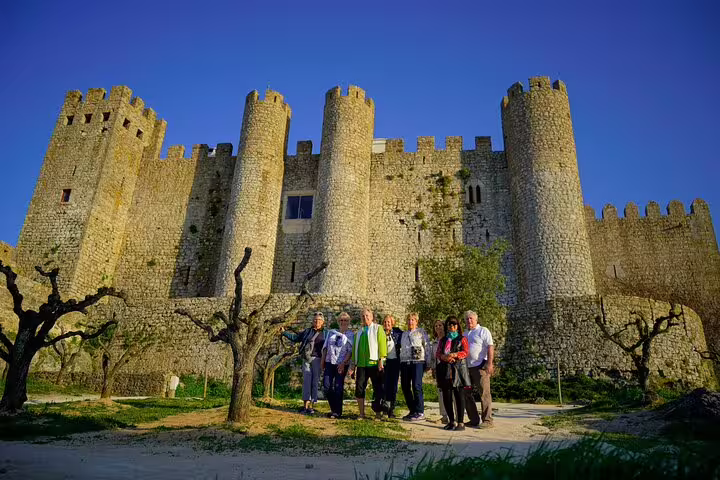 Group of tourists exploring the medieval Obidos Castle during a Fatima, Nazare, and Obidos private tour from Lisbon.