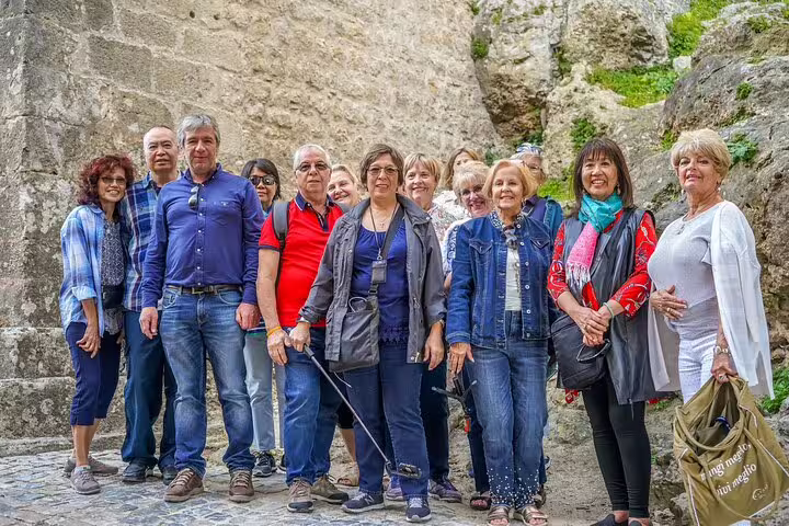 A group of tourists exploring historic stone architecture during the Fatima, Nazare, and Obidos full-day private tour from Lisbon.