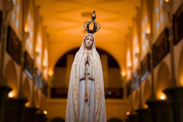 Statue of Our Lady of Fatima in a beautifully lit church, highlighting the religious significance of the Fatima and Coimbra tour.