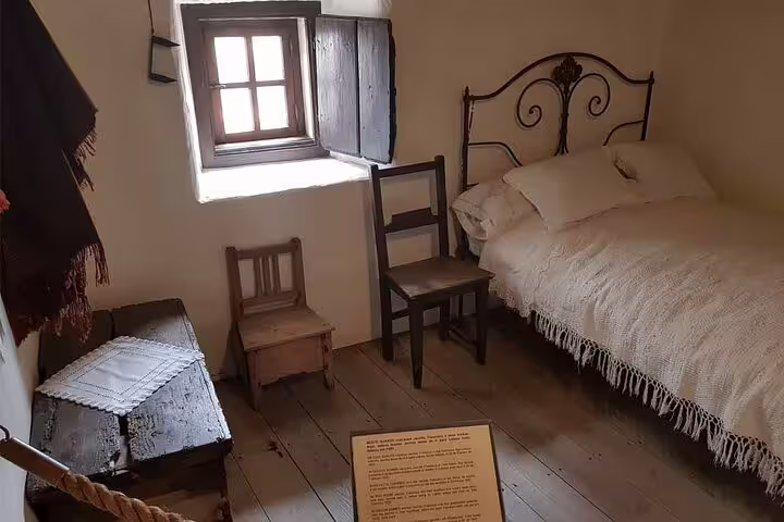 Rustic bedroom in Fatima with vintage wooden furniture, showcasing traditional Portuguese decor on a private half-day tour from Lisbon.