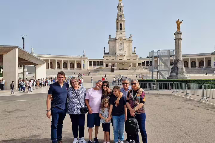 A group of tourists enjoying the Fatima Sanctuary during a full-day private tour from Lisbon, capturing the iconic basilica.