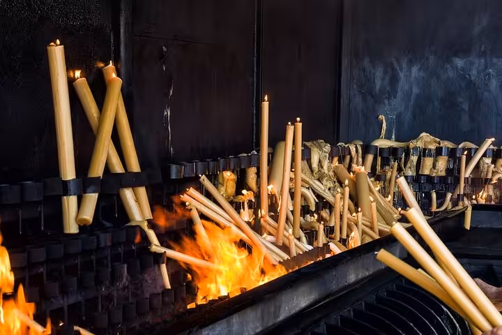 Candles burn brightly at a Fátima sanctuary, capturing the solemnity and devotion on a private tour from Lisbon.