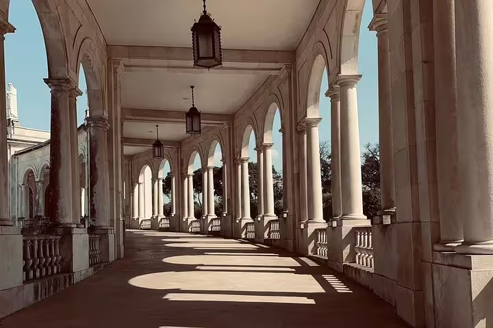 Elegant arched colonnade at Fátima Sanctuary, featured in small group day trips from Lisbon, highlighting architectural beauty.
