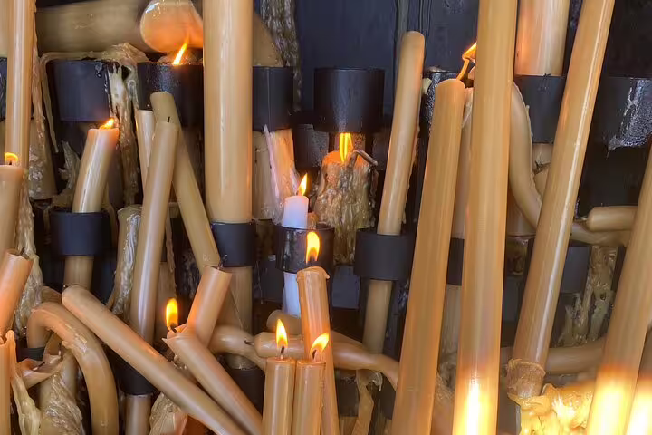 Close-up of devotional candles burning brightly at the Sanctuary of Fátima, symbolizing prayer and reflection.