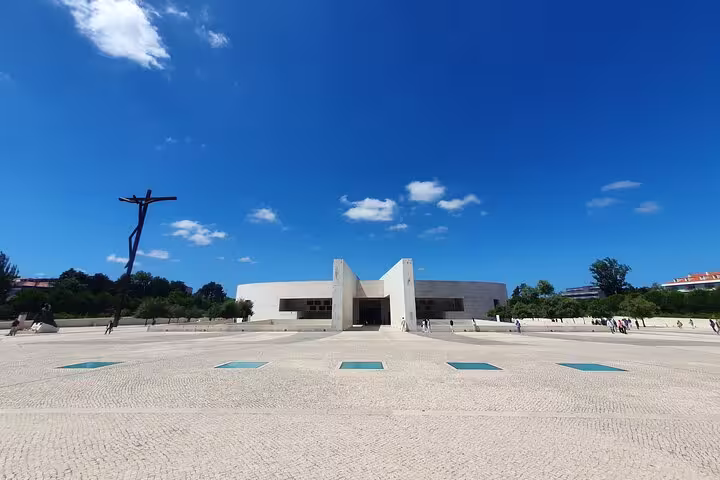 Modern architectural building at Fátima Sanctuary under a clear blue sky, featured in the Lisboa small-group tour.
