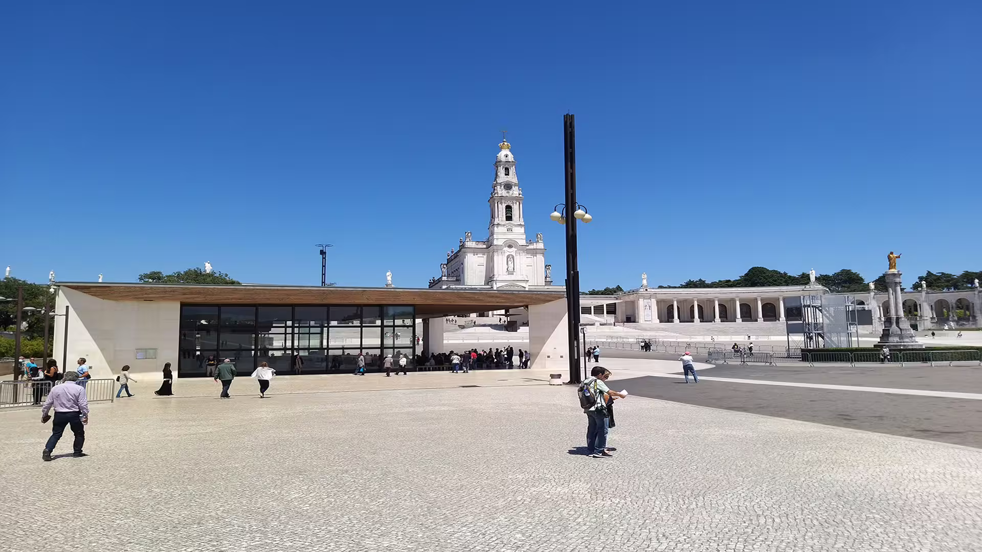 Panoramic view of Fátima Sanctuary's grand architecture under a clear blue sky, highlighting a popular private tour destination.