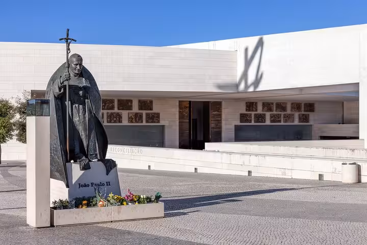 Statue at Fátima Sanctuary with modern architecture, part of the private tour from Lisbon.