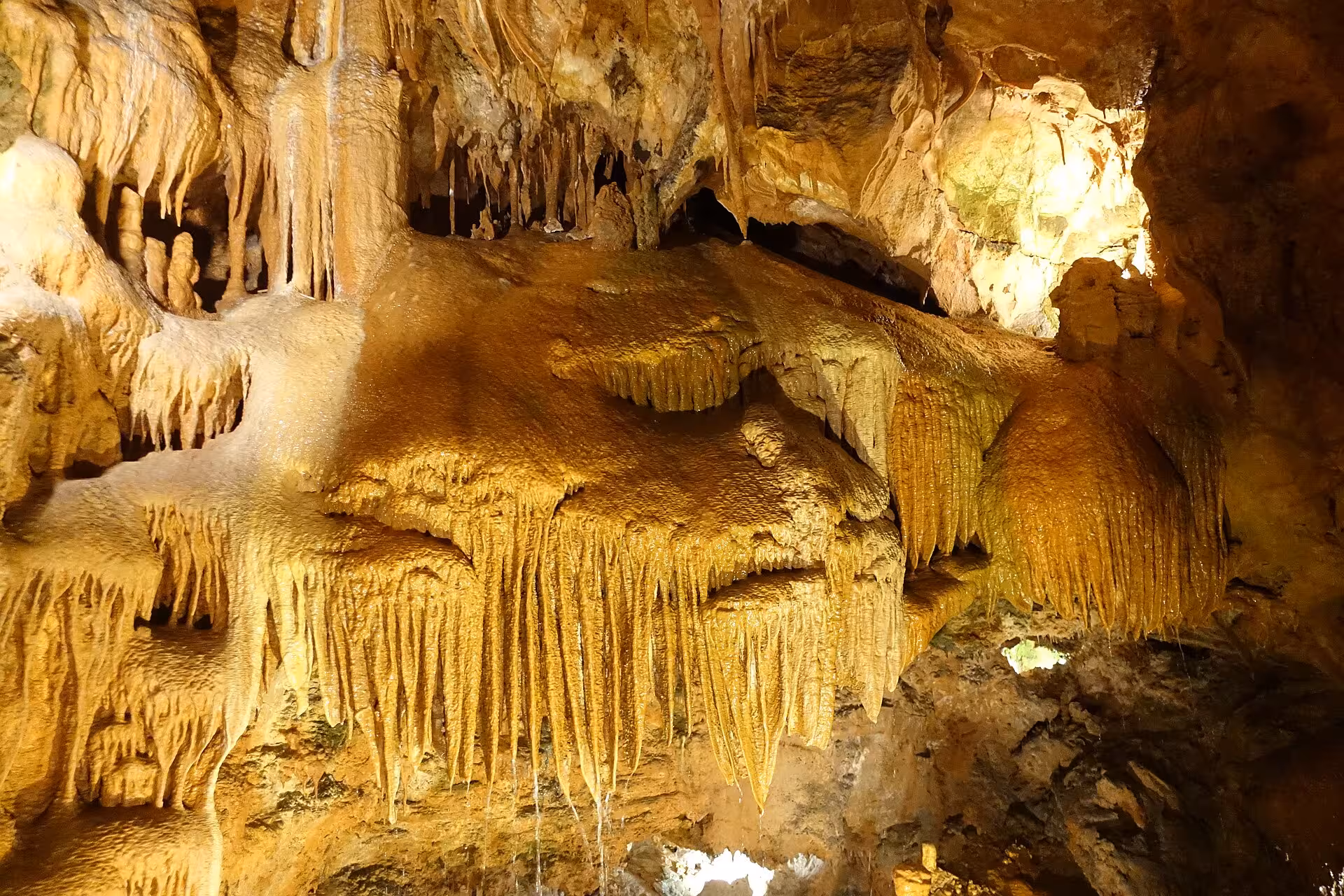 Golden stalactites and flowstone cave in Serra de Aire, optional nature stop on private Fátima e-bike adventure
