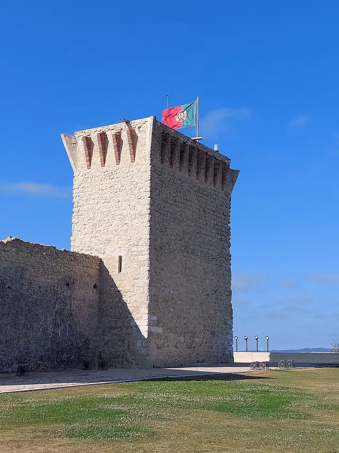 Medieval stone castle tower with Portuguese flag, scenic stop on private Fátima & Serra de Aire e-bike tour