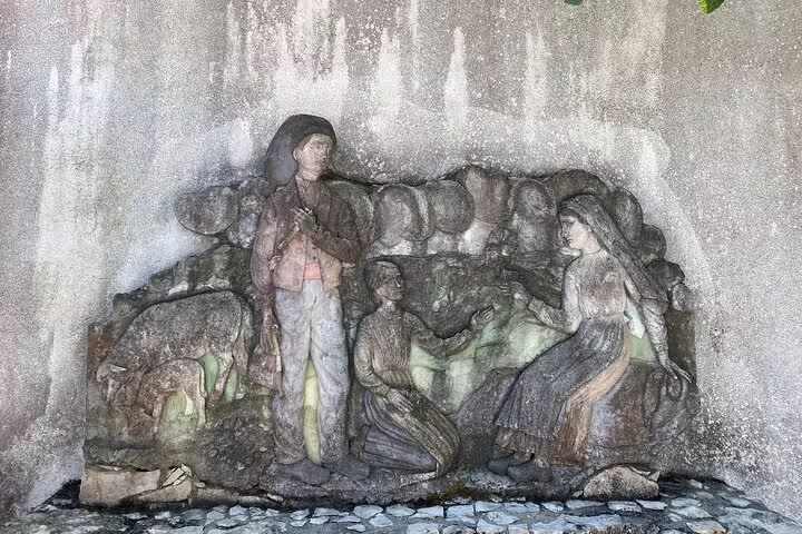 Sculpture depicting the Fatima shepherd children in a stone relief, highlighting cultural heritage on a Lisbon tour.
