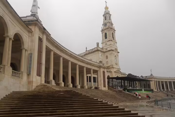 View of the stunning architecture of the Fatima Shrine, highlighting its grand colonnades and iconic bell tower.
