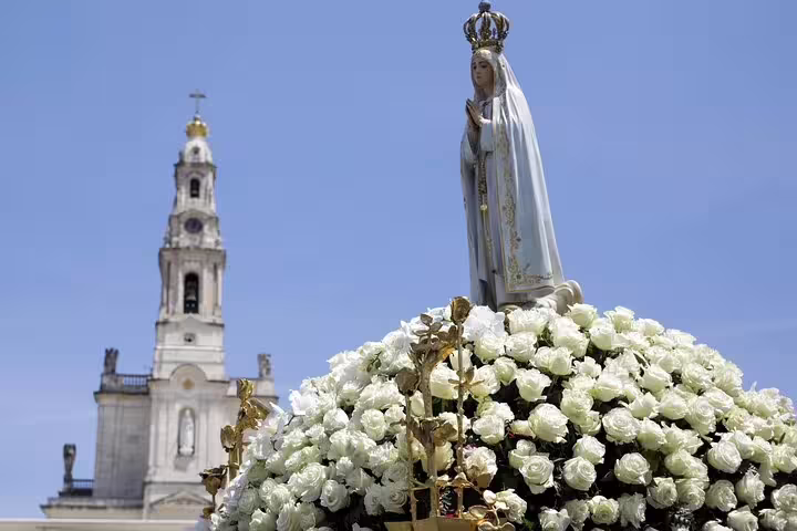 Statue of Our Lady of Fatima adorned with white roses in front of the Basilica during a private tour from Porto.