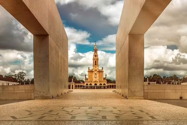 View of the iconic Fatima Shrine framed by modern architecture under a dramatic sky, perfect for a private visit from Porto.