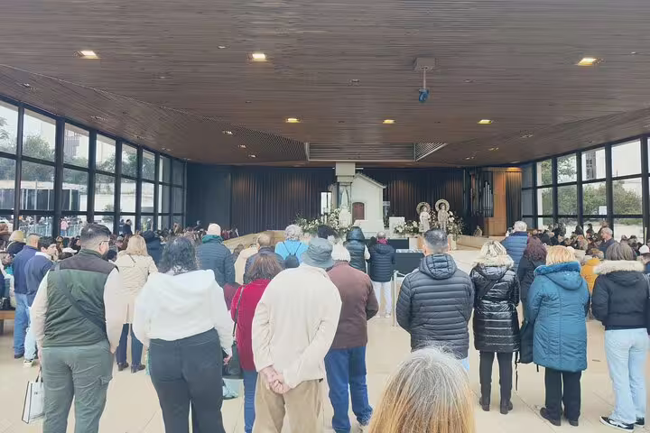 Visitors participate in a spiritual gathering inside a chapel at Fátima, reflecting the sacred atmosphere of the pilgrimage site.