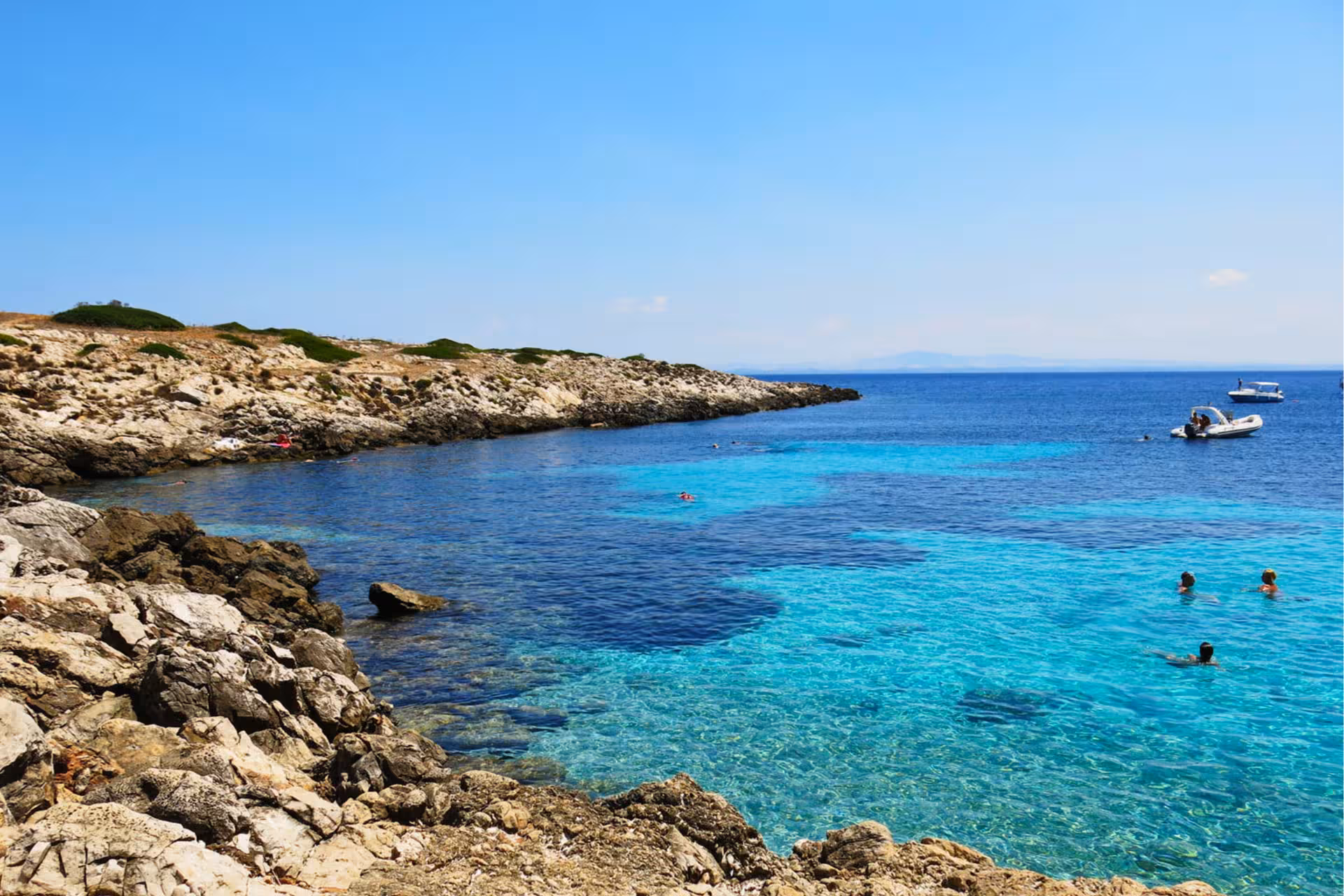 Swimmers in crystal-clear Favignana bay, snorkeling stop on Egadi Islands boat excursion to Levanzo from Trapani