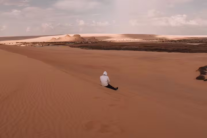 Solo traveler on sweeping Fayoum sand dunes, Egypt, during a full-day bird watching and desert safari tour