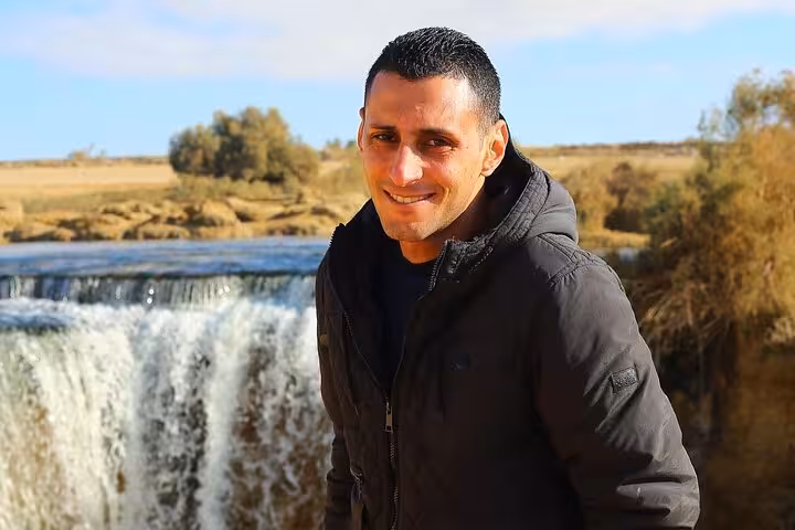 Traveler enjoying scenic waterfall view during Fayoum Oasis Jeep tour from Cairo.
