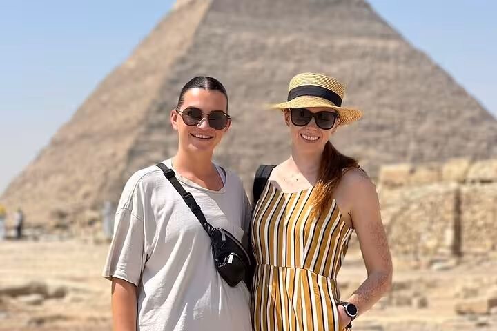 Two travelers pose at Giza Pyramid on a private tour with an expert female Egyptologist guide in Cairo