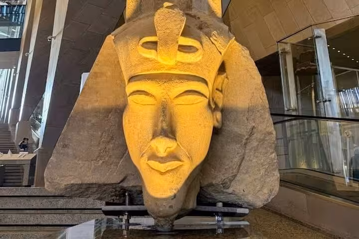 Colossal pharaoh head in Grand Egyptian Museum, guided by expert female Egyptologist on Cairo day tour