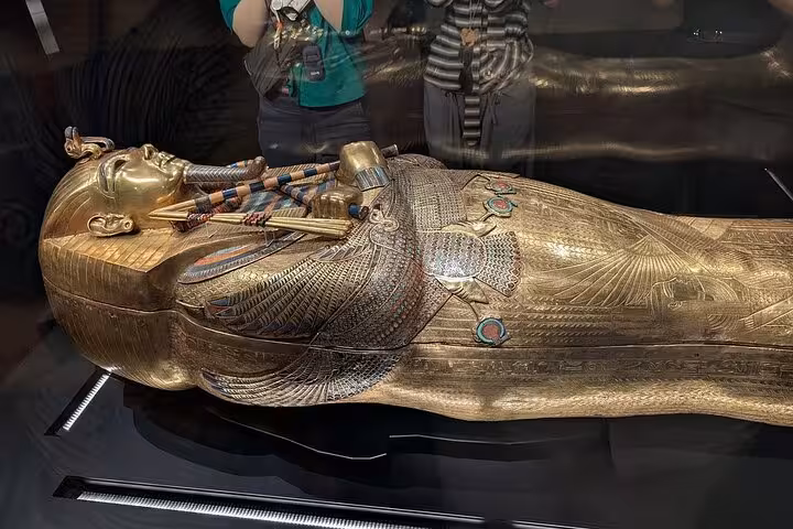 Gilded ancient Egyptian sarcophagus display at Grand Egyptian Museum, expert female Egyptologist tour Cairo