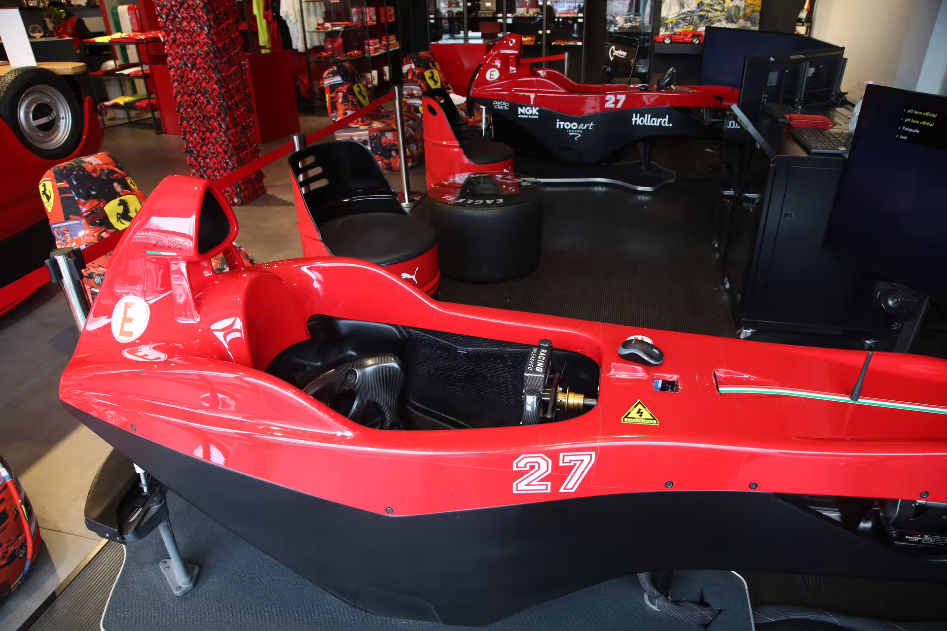Close-up of a red F1 racing simulator cockpit at Museo Ferrari in Maranello, showcasing professional driving experience.