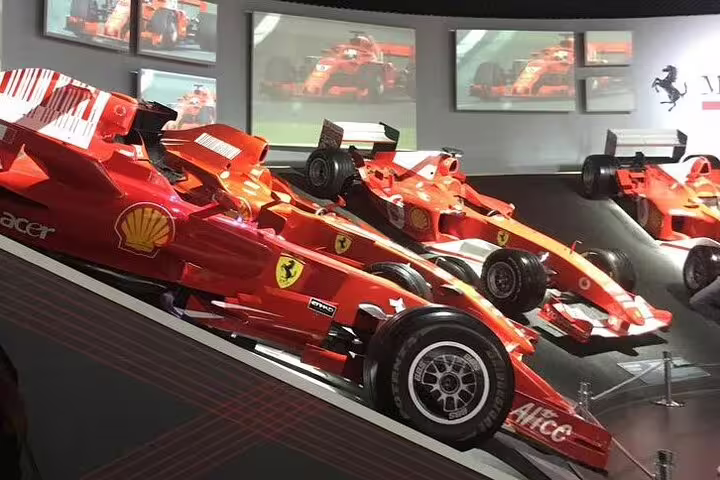 Iconic red Formula 1 racing cars on display inside the Ferrari Museum in Modena during a private guided tour experience