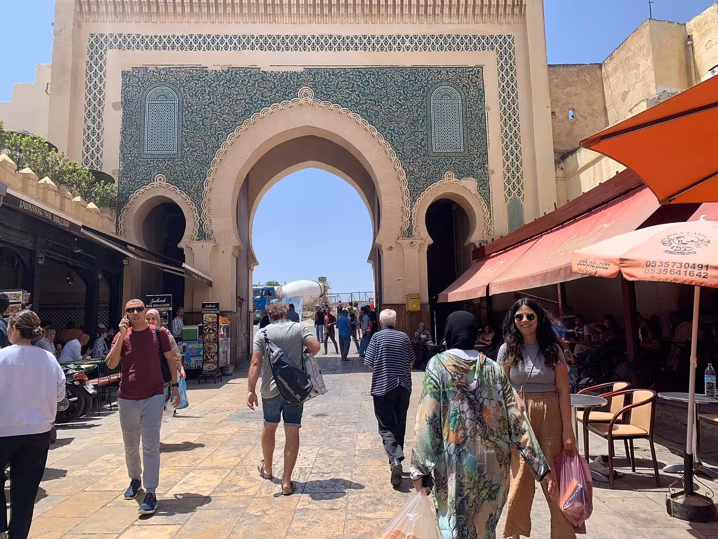 Bustling Fes Medina market with vibrant architecture, a key stop on the Fes to Merzouga or Marrakech transfer tour.