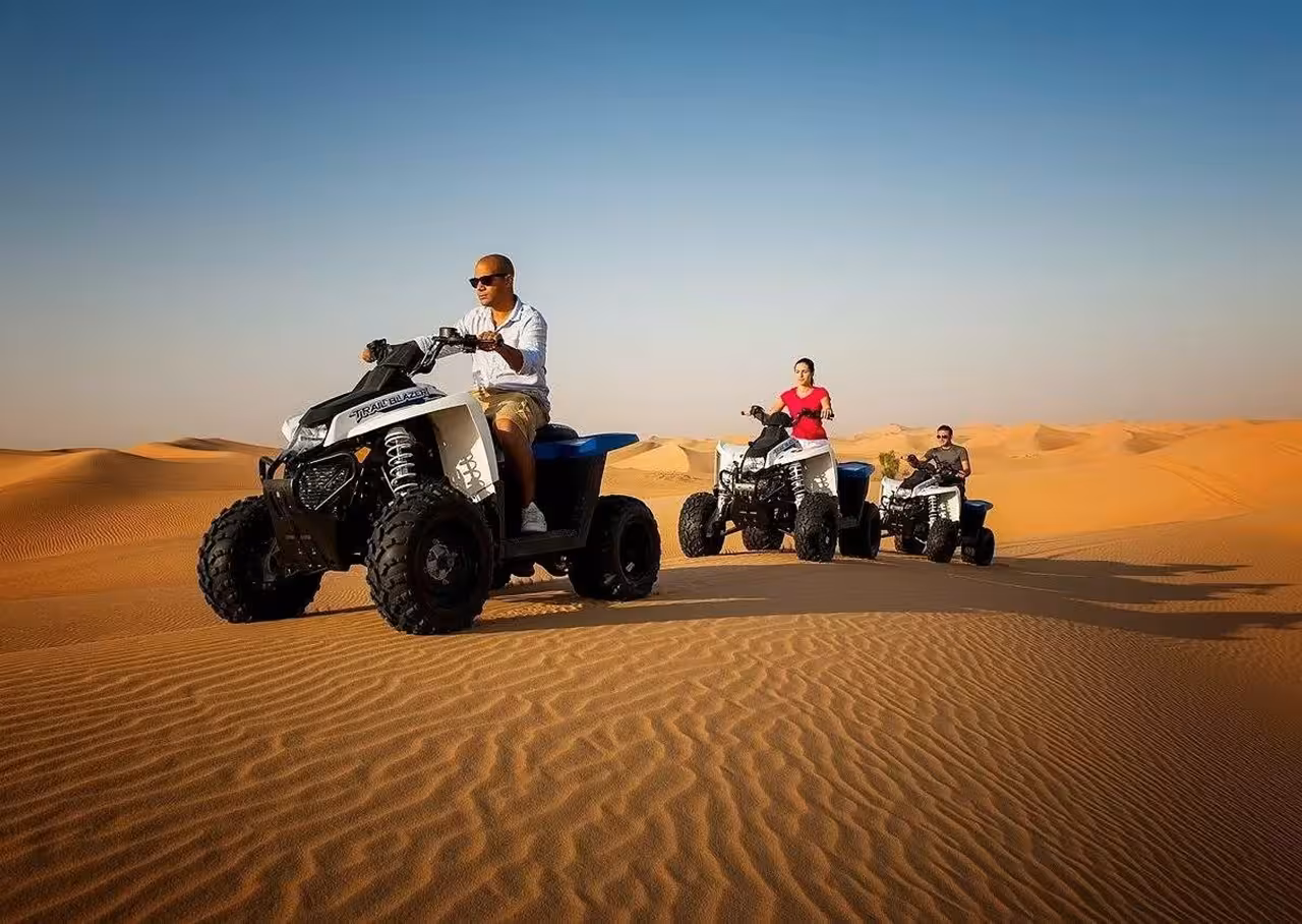 Group enjoying an exciting ATV ride across the golden dunes on a Fes to Merzouga Erg-chebbi desert adventure.