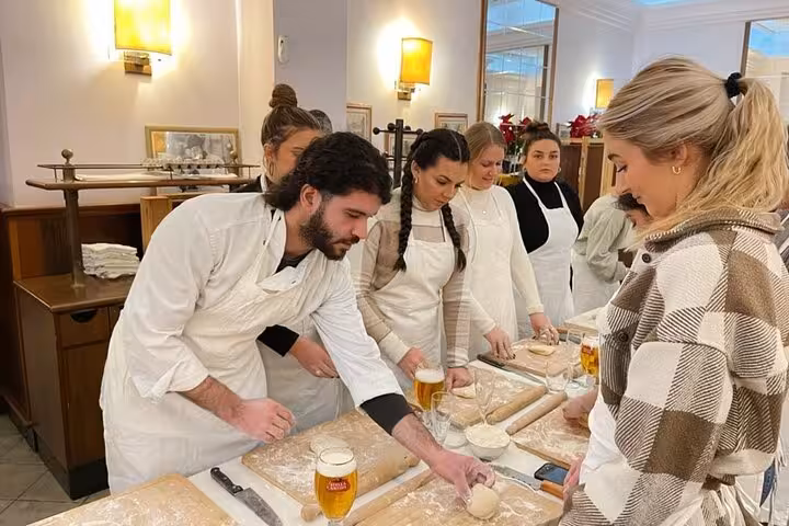 Participants learning to make fettuccine in a hands-on cooking class in Rome's city center with expert guidance.