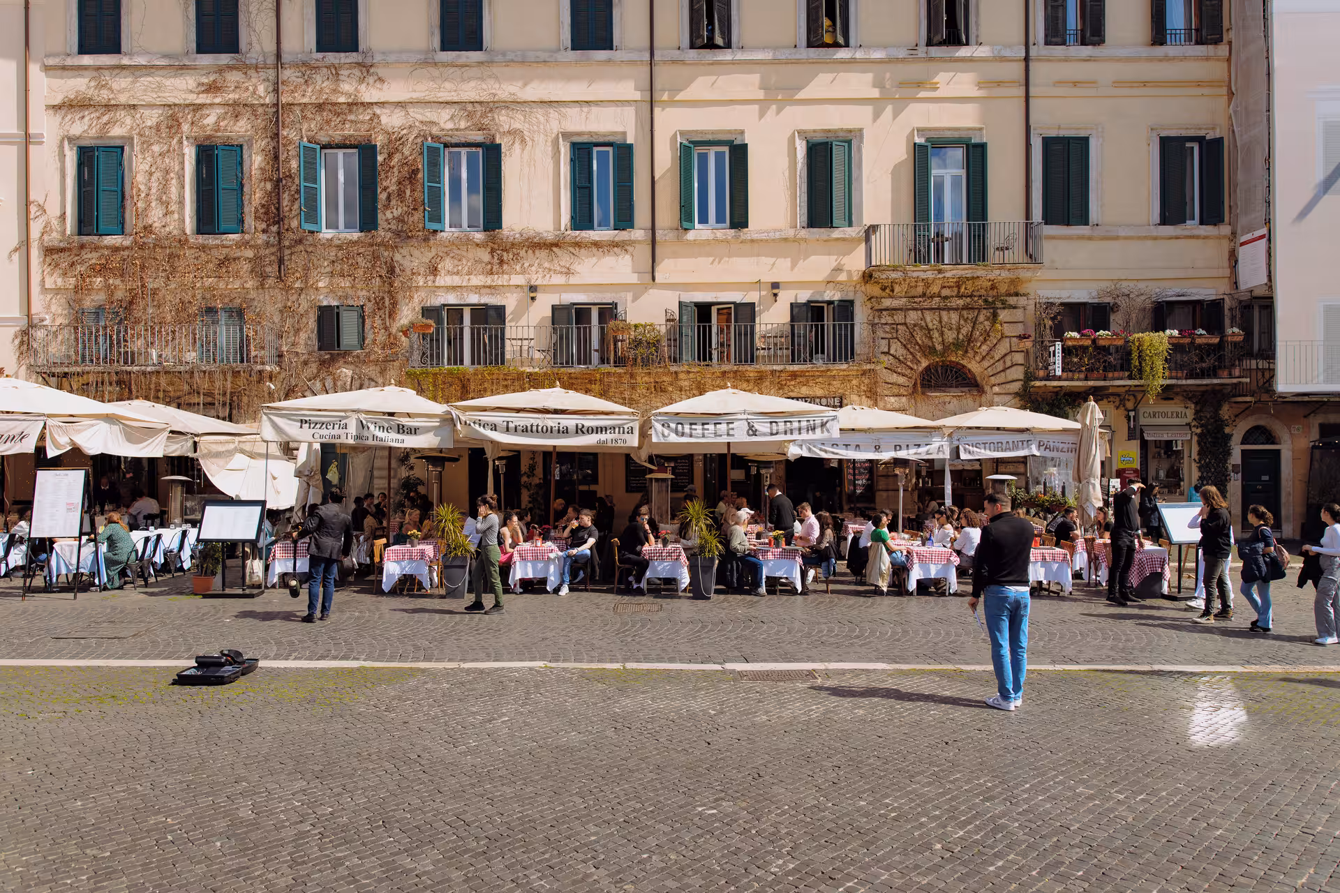 Diners relax at outdoor cafes in a lively Roman piazza, capturing the essence of Italian culture.