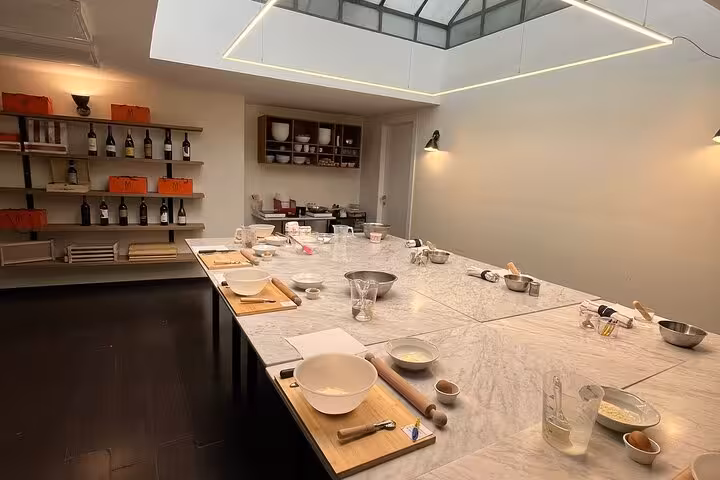 Spacious kitchen setup for a hands-on fettuccine pasta and tiramisù dessert cooking class with ingredients and tools.