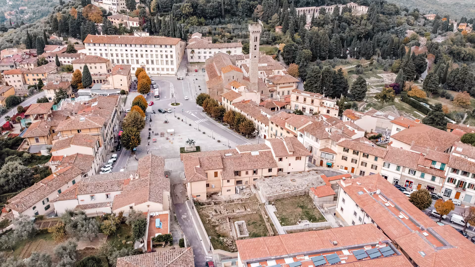 Aerial view of Fiesole's charming town center surrounded by lush Tuscan hills and historic architecture.