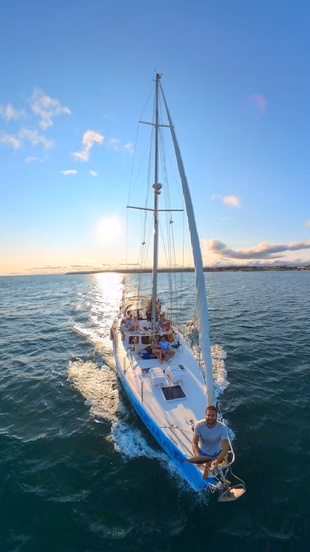 Aerial view of FINISMAR yacht cruising at sunset with passengers enjoying a scenic 3-hour tour on the open sea.