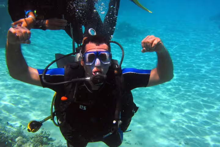 First-time scuba diver in clear lagoon water posing underwater on an intro diving and snorkeling tour