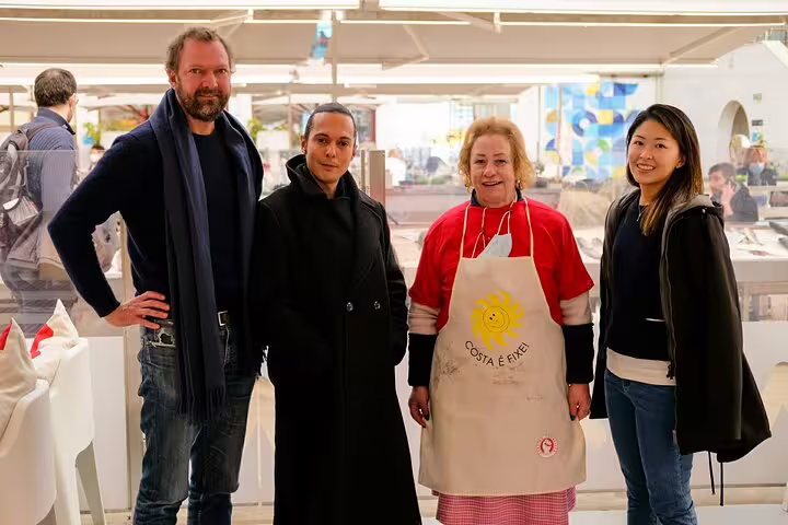 Group of four happy participants enjoying the Only Fish Market Tasting Tour, showcasing local seafood and cultural experiences.